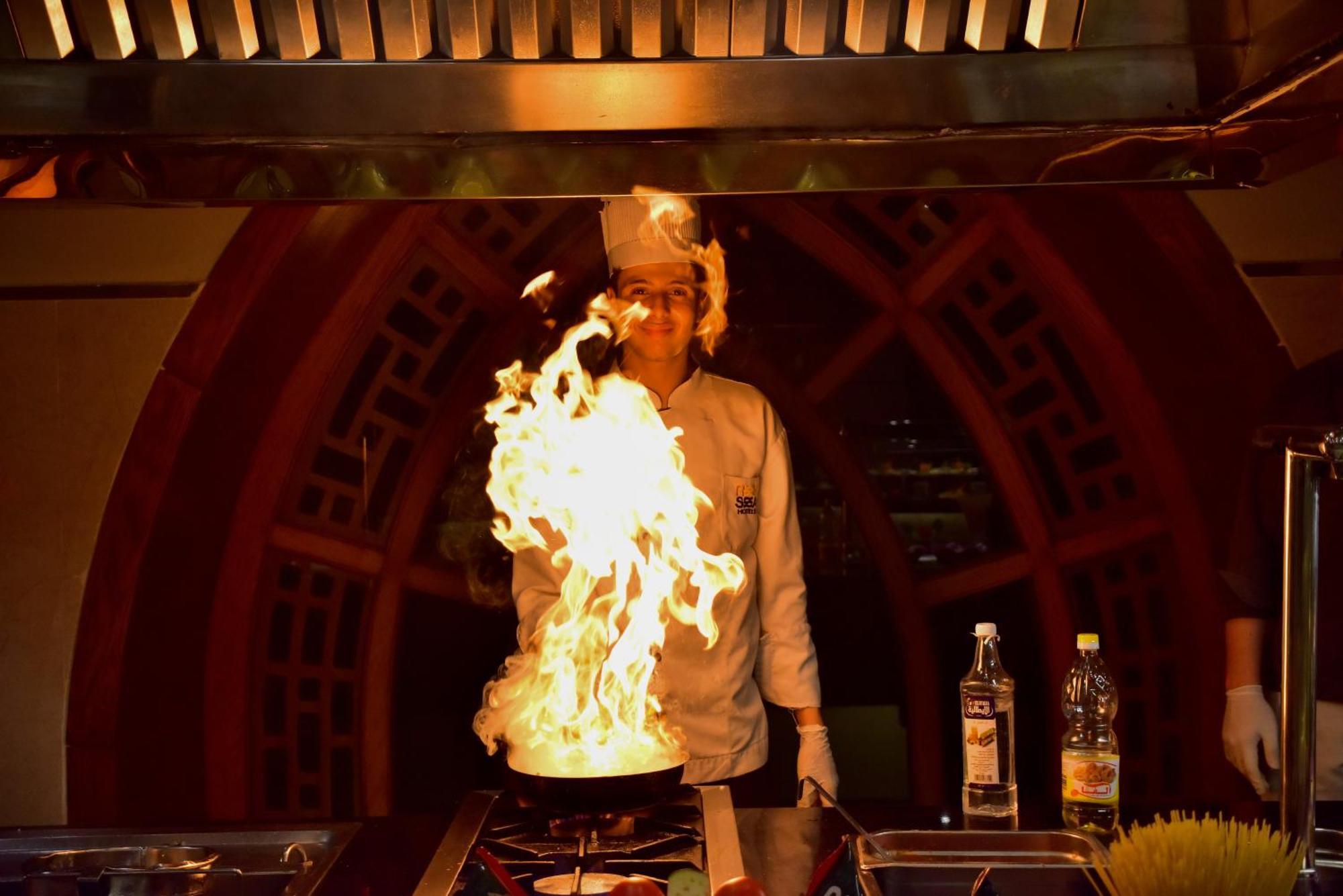 The Grand Hotel Sharm El Sheikh Exterior photo A chef cooking with a flaming wok